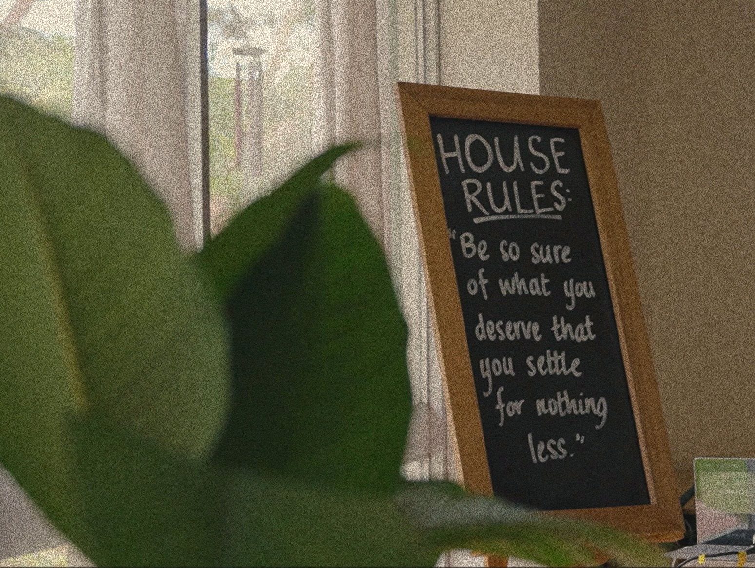 A chalkboard reading “Be so sure of what you deserve that you settle for nothing less”