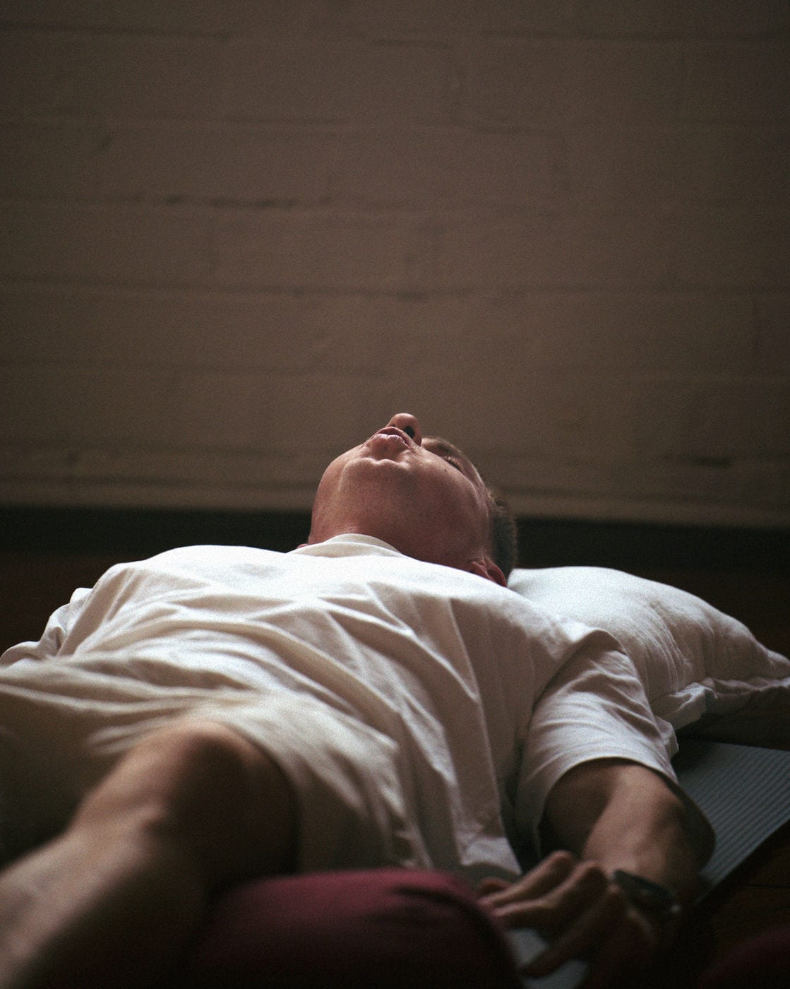 A participant lying back on a bolster during breathwork